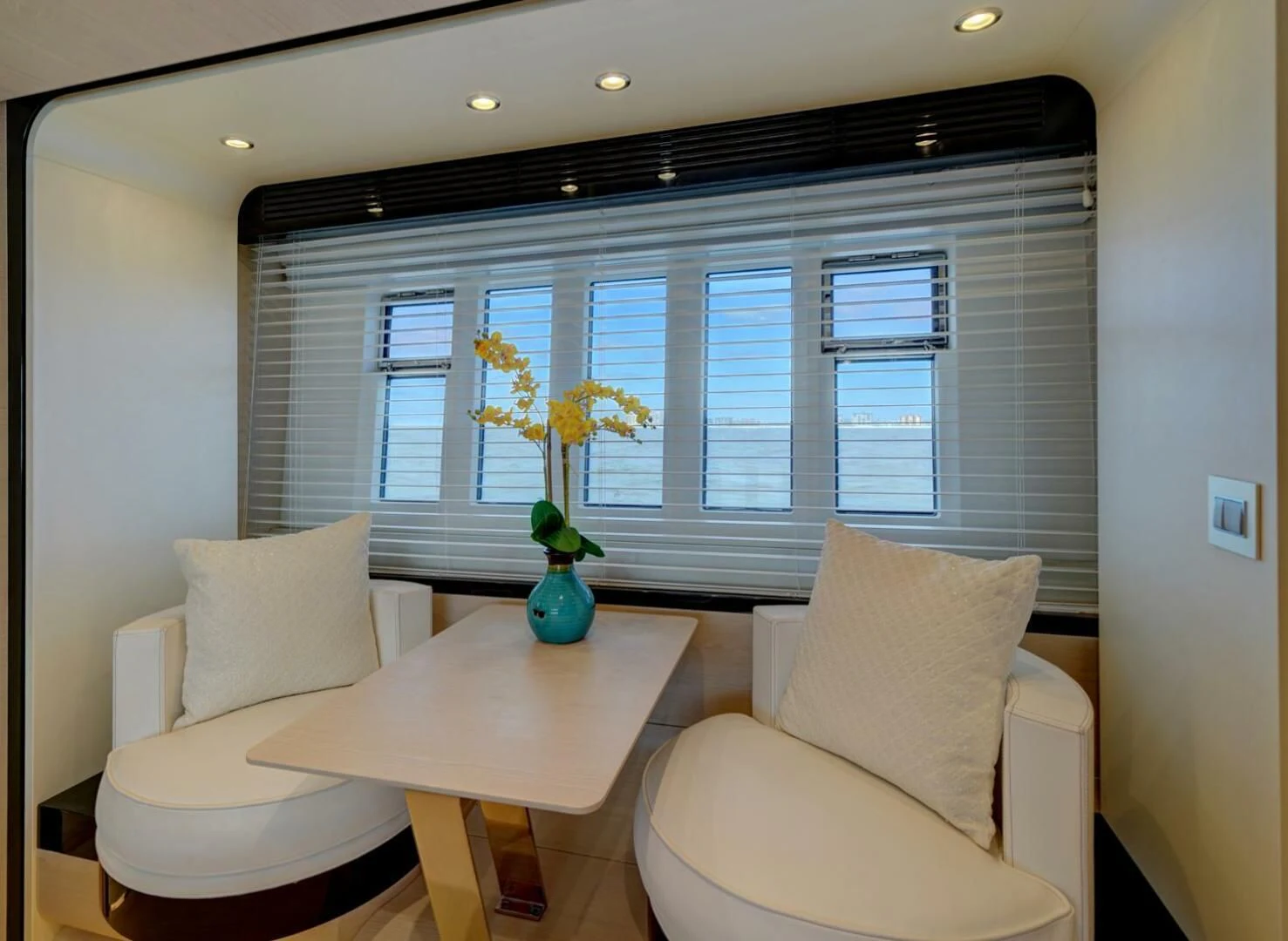 a living room with a vase of yellow flowers aboard 80 AZIMUT Yacht for Sale
