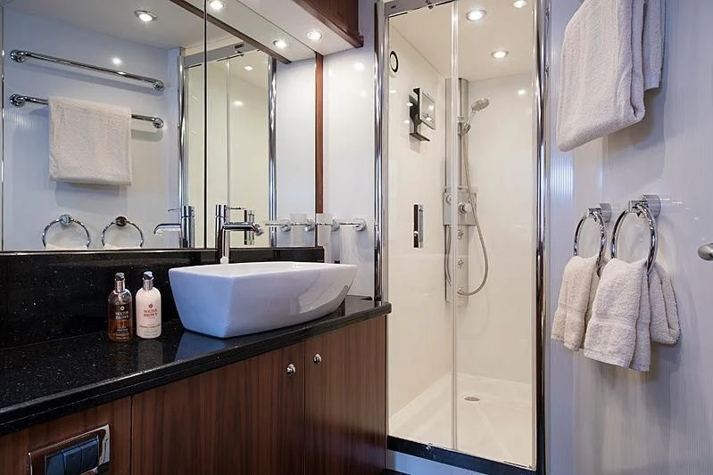 a bathroom with a shower sink and mirror aboard INFINITO Yacht for Sale