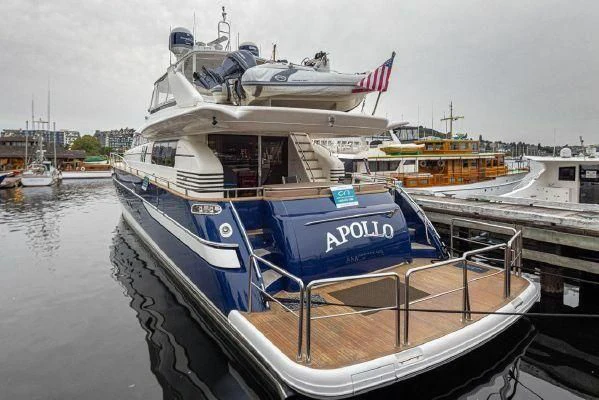 a boat docked at a pier with HMS M33 in the background aboard APOLLO Yacht for Sale