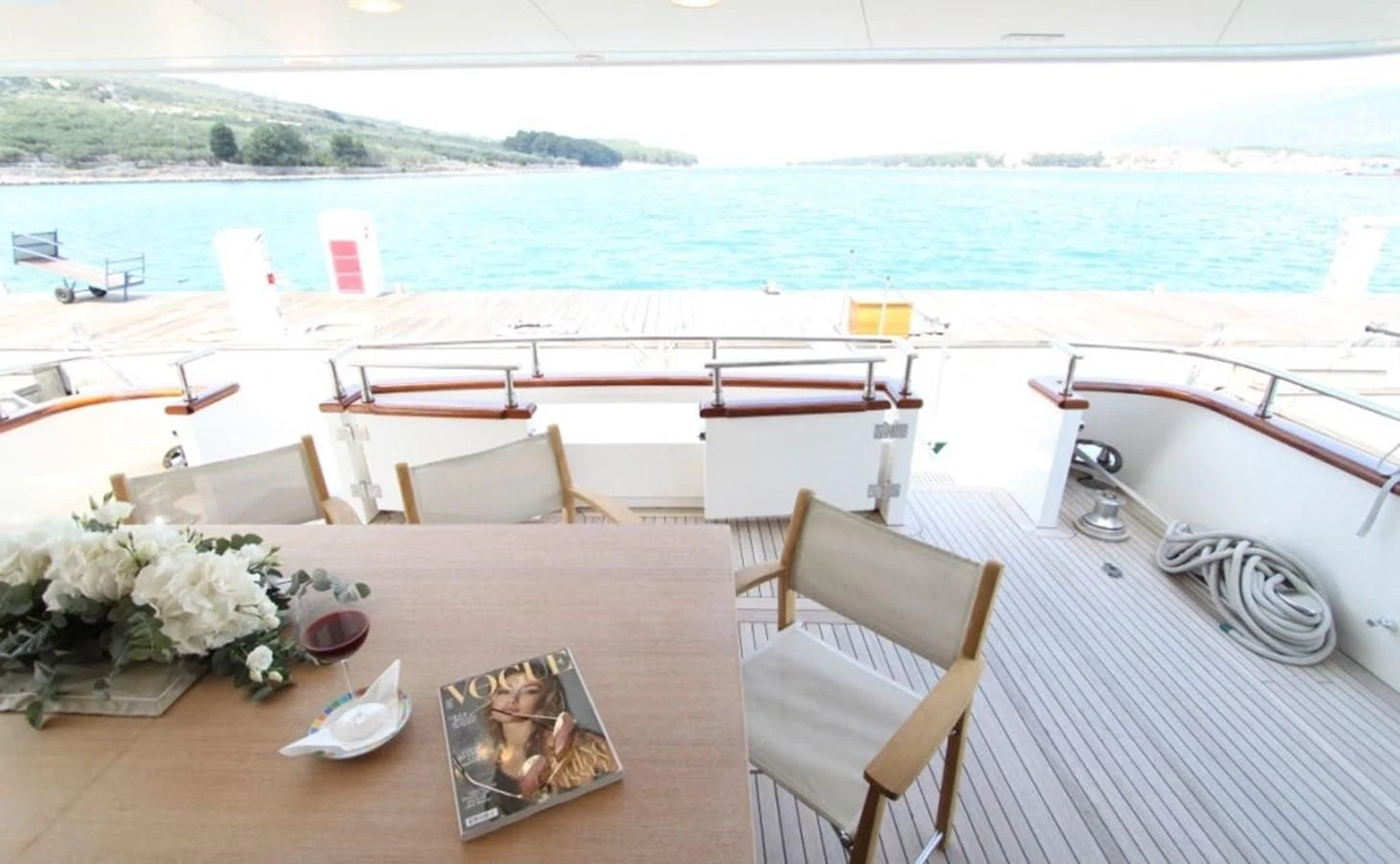 a table with chairs on it next to a body of water aboard ACCI Yacht for Sale