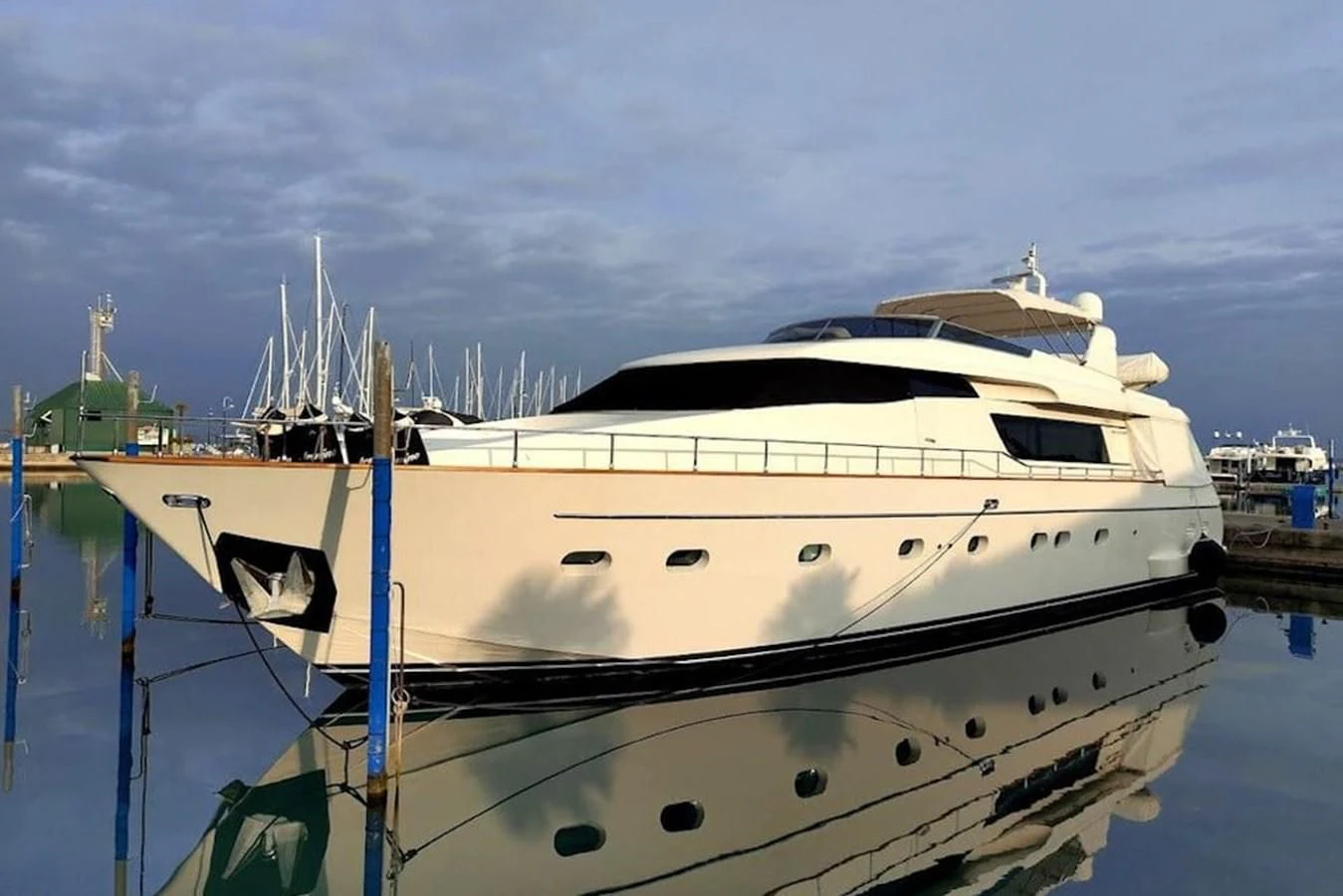 a white yacht in a harbor aboard ACCI Yacht for Sale