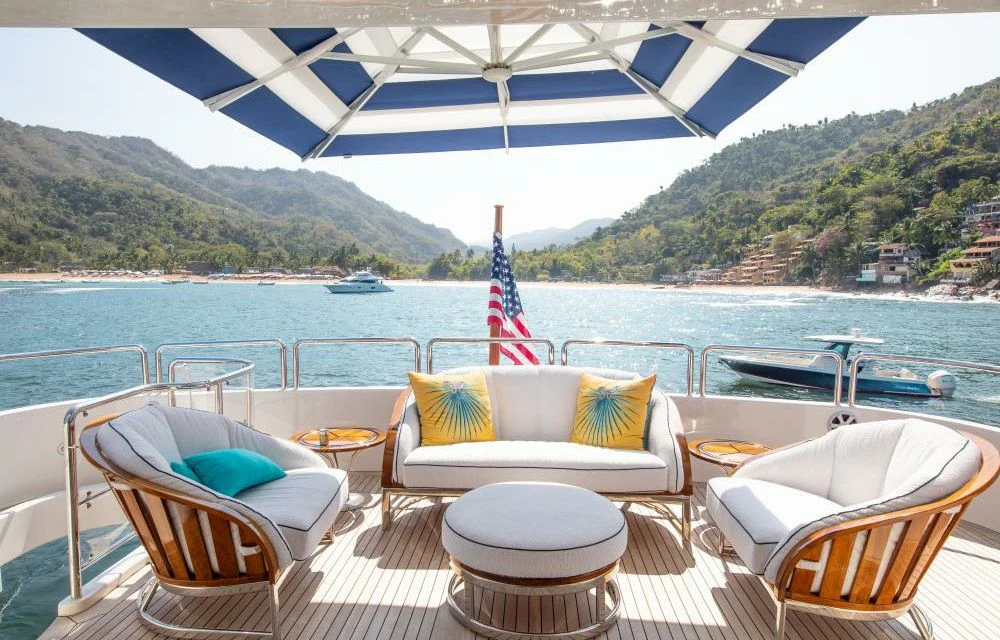 a table and chairs on a deck overlooking a body of water aboard FELICITA Yacht for Sale
