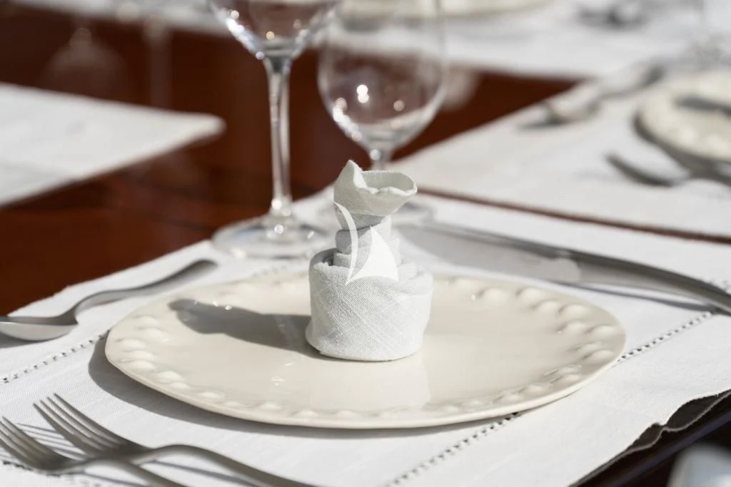 a white cake with a white bow on a plate with a fork and knife aboard QUID PRO QUO Yacht for Sale
