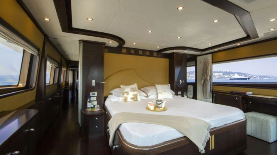 a room with a bed and a television aboard QUID PRO QUO Yacht for Sale