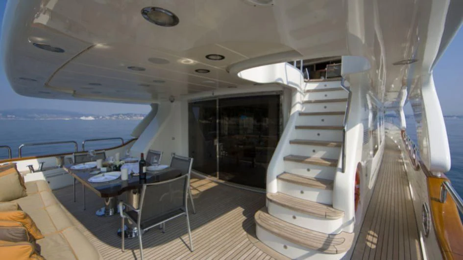 a boat with a staircase and a table and chairs aboard QUID PRO QUO Yacht for Sale