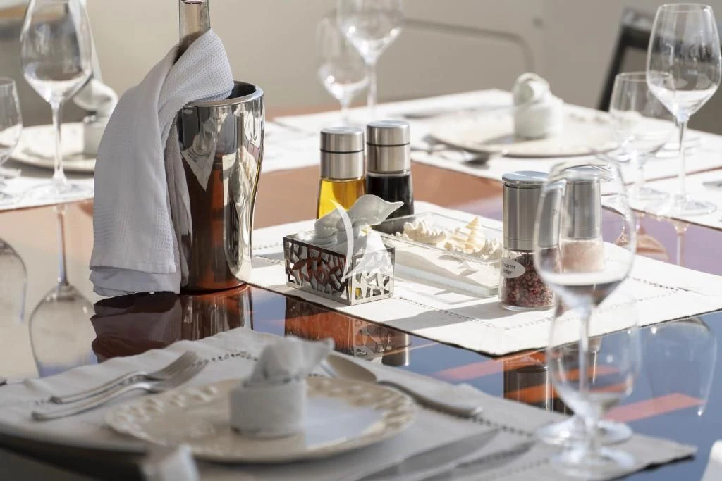 a table with plates and glasses aboard QUID PRO QUO Yacht for Sale