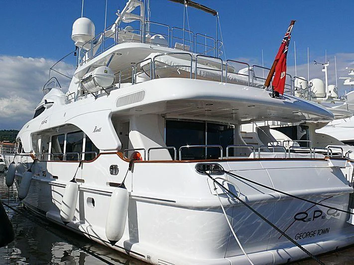 a white boat with a red flag on the front aboard QUID PRO QUO Yacht for Sale
