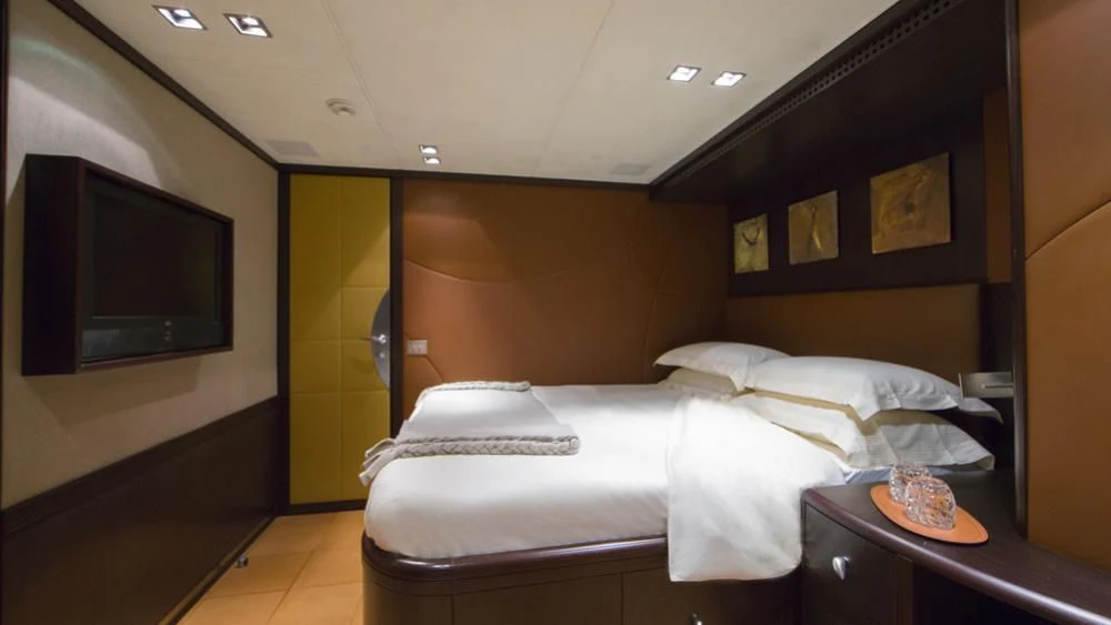 a hotel room with a bed and tv aboard QUID PRO QUO Yacht for Sale