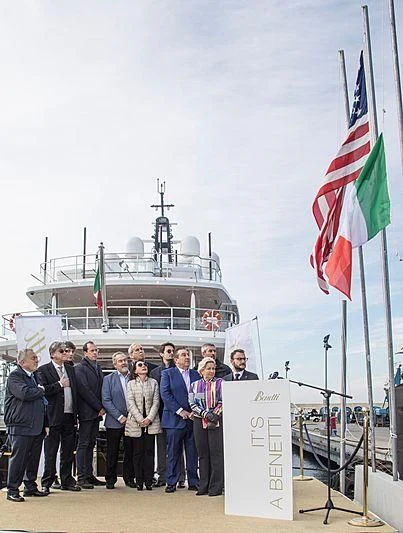 a group of people posing for a photo in front of a ship aboard SPECTRE Yacht for Sale