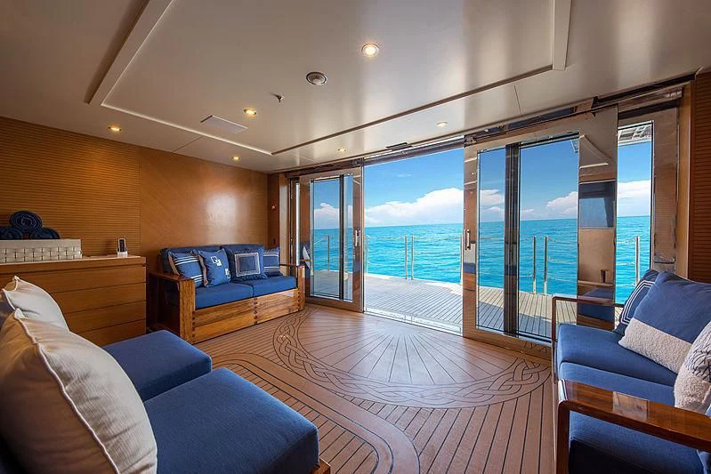 a living room with a large glass door and a balcony aboard SPECTRE Yacht for Sale