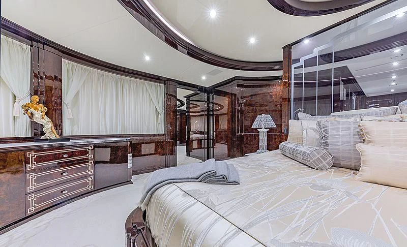 a bedroom with a bed and a dresser aboard SPECTRE Yacht for Sale