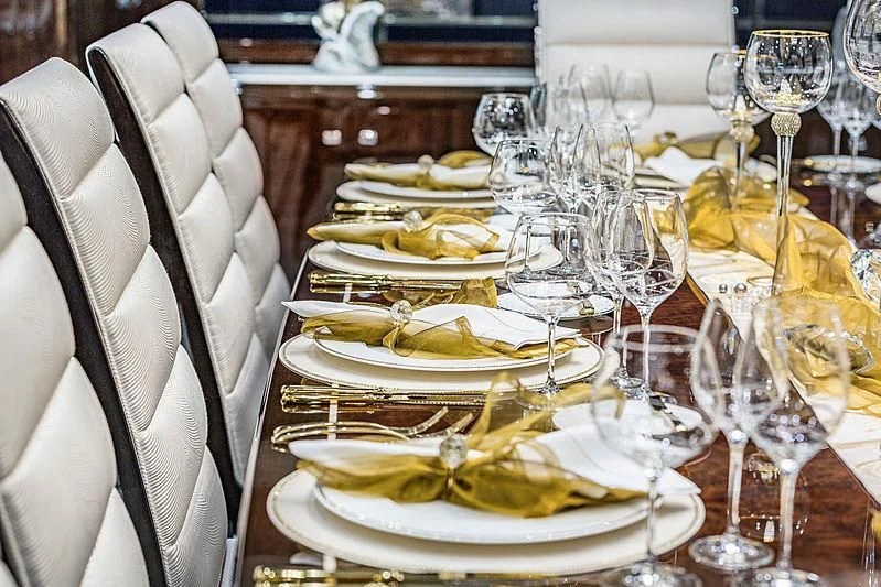 a table with a plate of food and glasses on it aboard SPECTRE Yacht for Sale