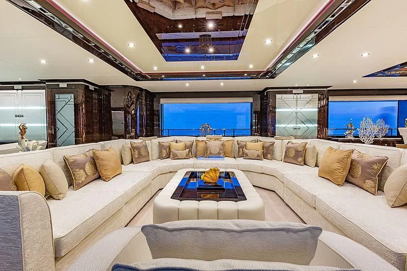 a large living room with a large sofa and a large window aboard SPECTRE Yacht for Sale