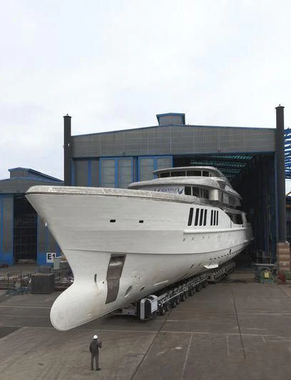a person standing next to a large building aboard SPECTRE Yacht for Sale