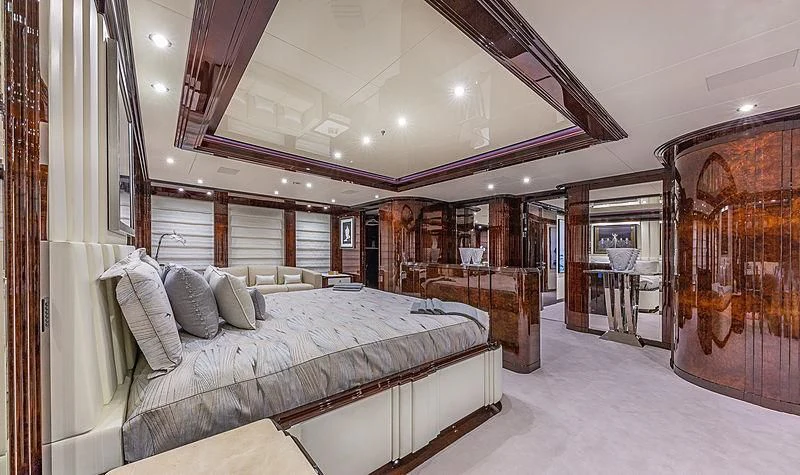 a bedroom with a bed and a mirror aboard SPECTRE Yacht for Sale