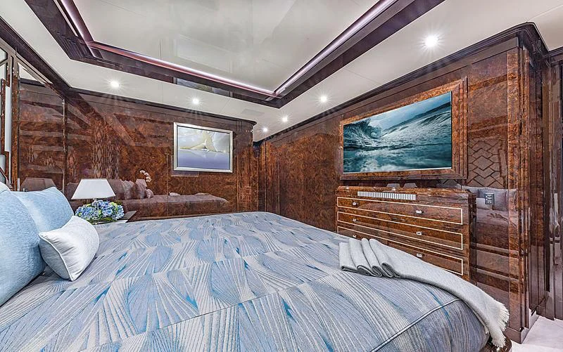 a bed with a television on the wall aboard SPECTRE Yacht for Sale