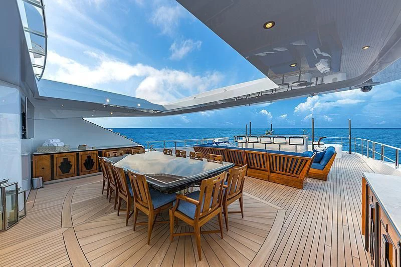 a deck with a table and chairs on it aboard SPECTRE Yacht for Sale