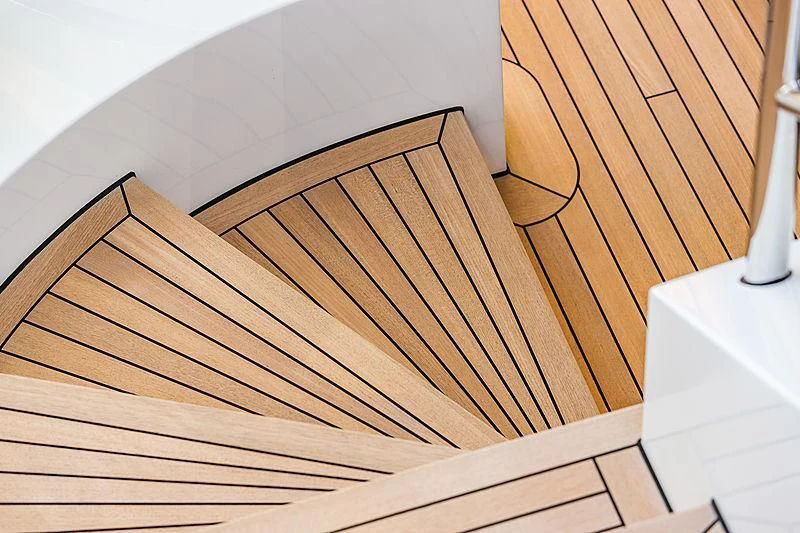 a wooden staircase with a glass railing aboard SPECTRE Yacht for Sale