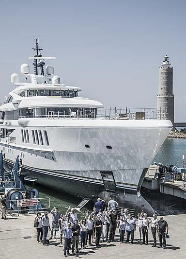 a group of people standing next to a large ship aboard SPECTRE Yacht for Sale