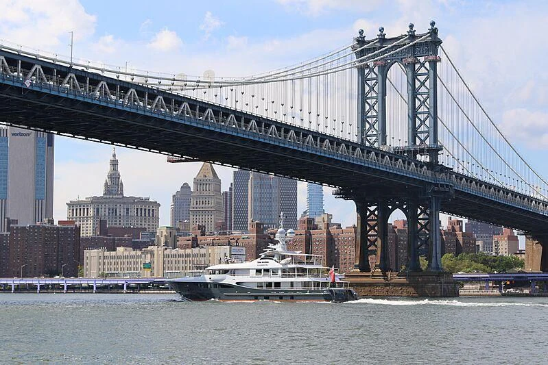 a boat under Manhattan Bridge aboard GENE MACHINE Yacht for Sale