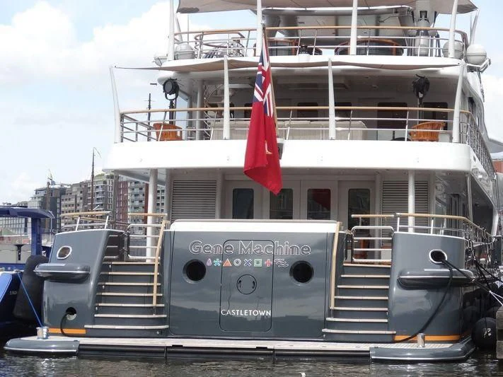 a large white boat with a flag on the front aboard GENE MACHINE Yacht for Sale