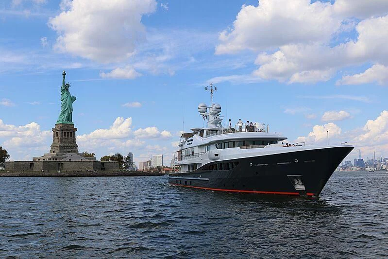 a boat in the water by a statue aboard GENE MACHINE Yacht for Sale