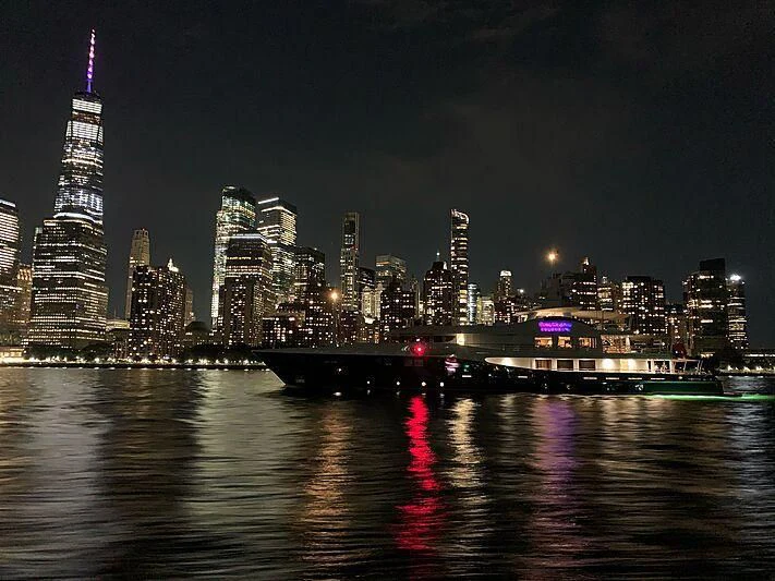 a city skyline at night aboard GENE MACHINE Yacht for Sale