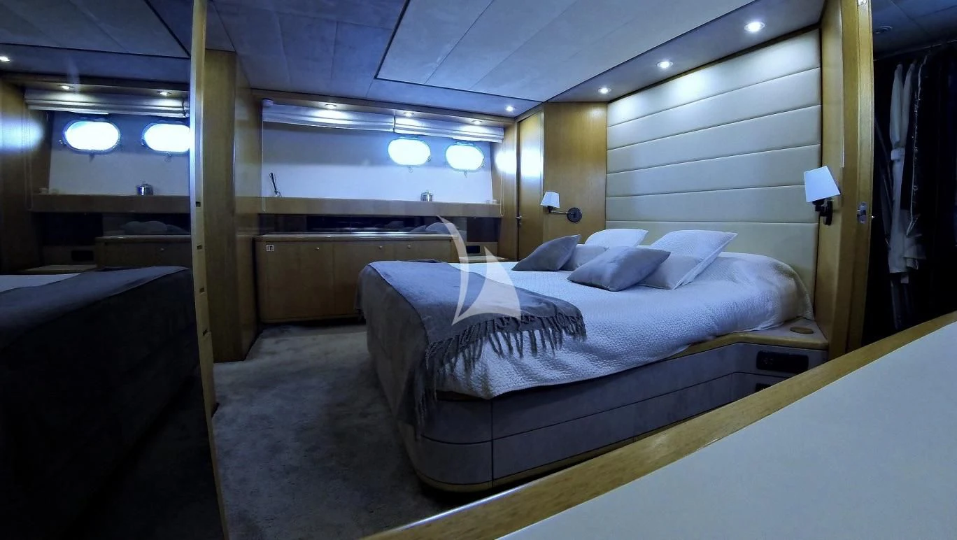 a room with a bed and a desk aboard LOLEA Yacht for Charter