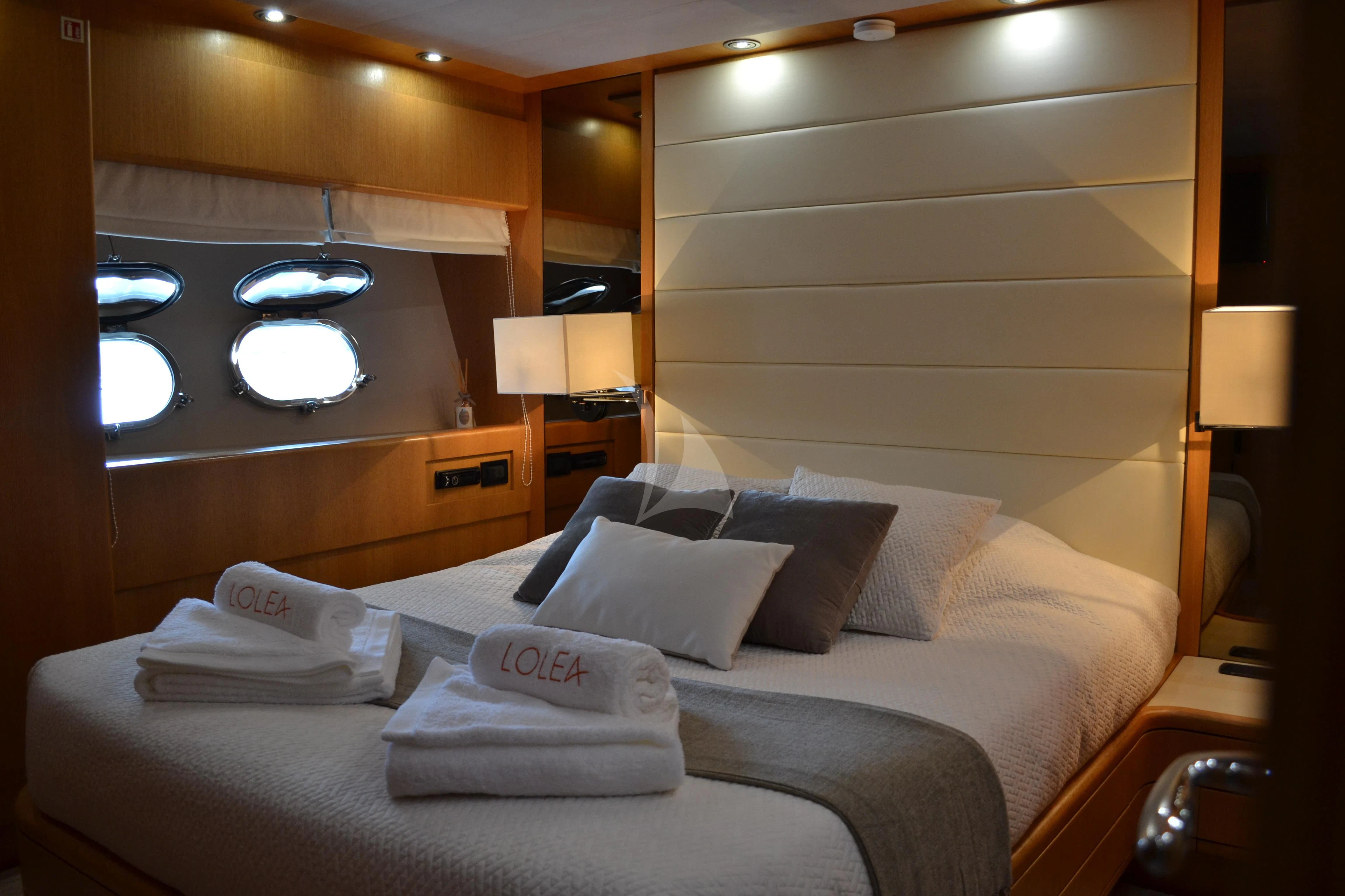 a bed with pillows and a lamp aboard LOLEA Yacht for Charter
