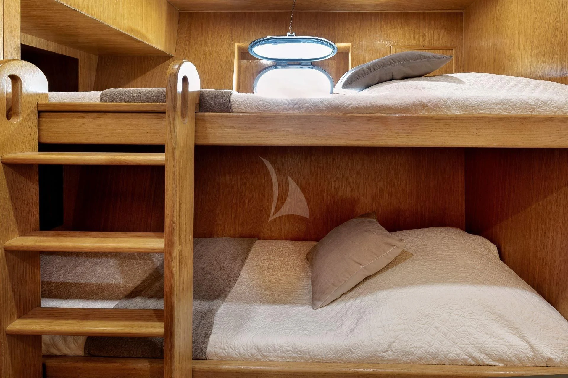 a bed with a wooden headboard aboard LOLEA Yacht for Charter