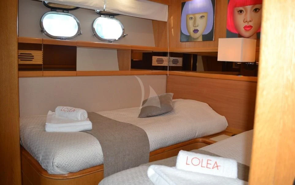 a room with a bed and a mirror aboard LOLEA Yacht for Charter