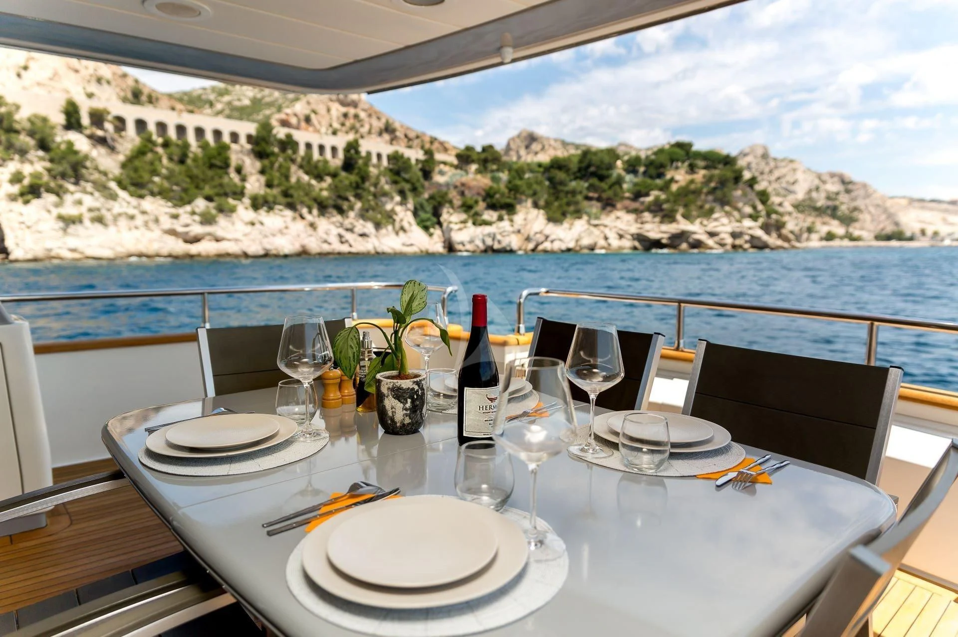 a table with wine glasses and plates on it aboard LOLEA Yacht for Charter