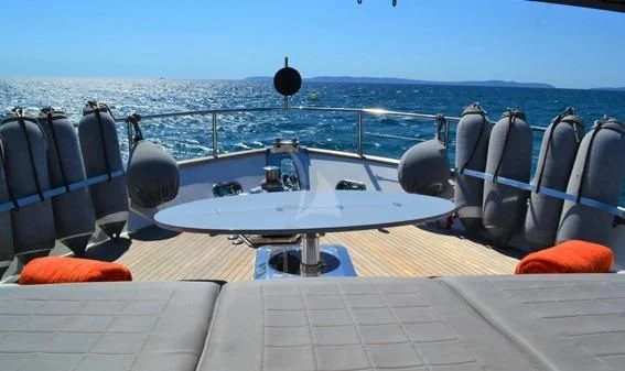 a deck with chairs and a table on it aboard LOLEA Yacht for Charter