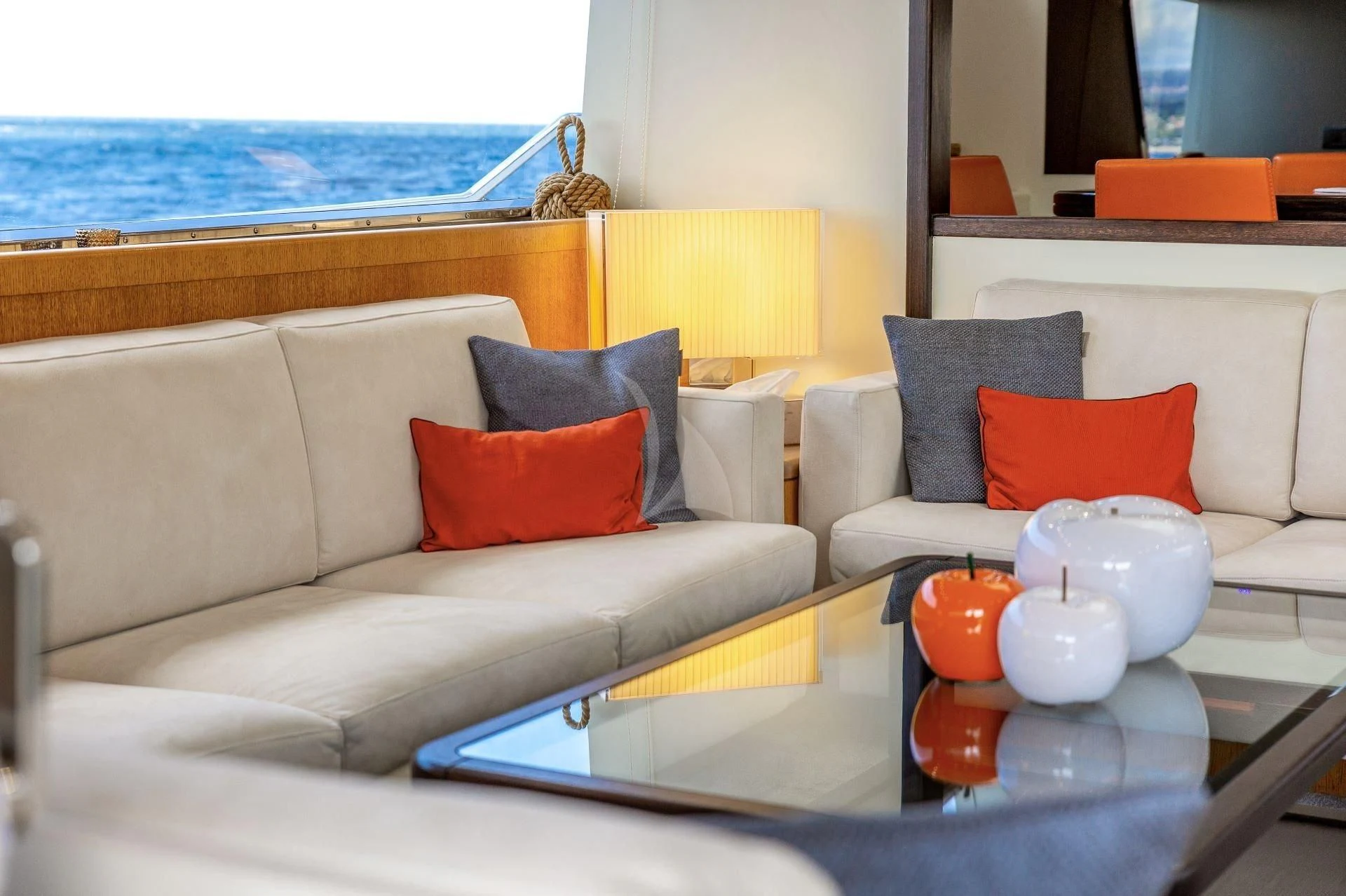 a white couch with pillows and orange pillows on it aboard LOLEA Yacht for Charter