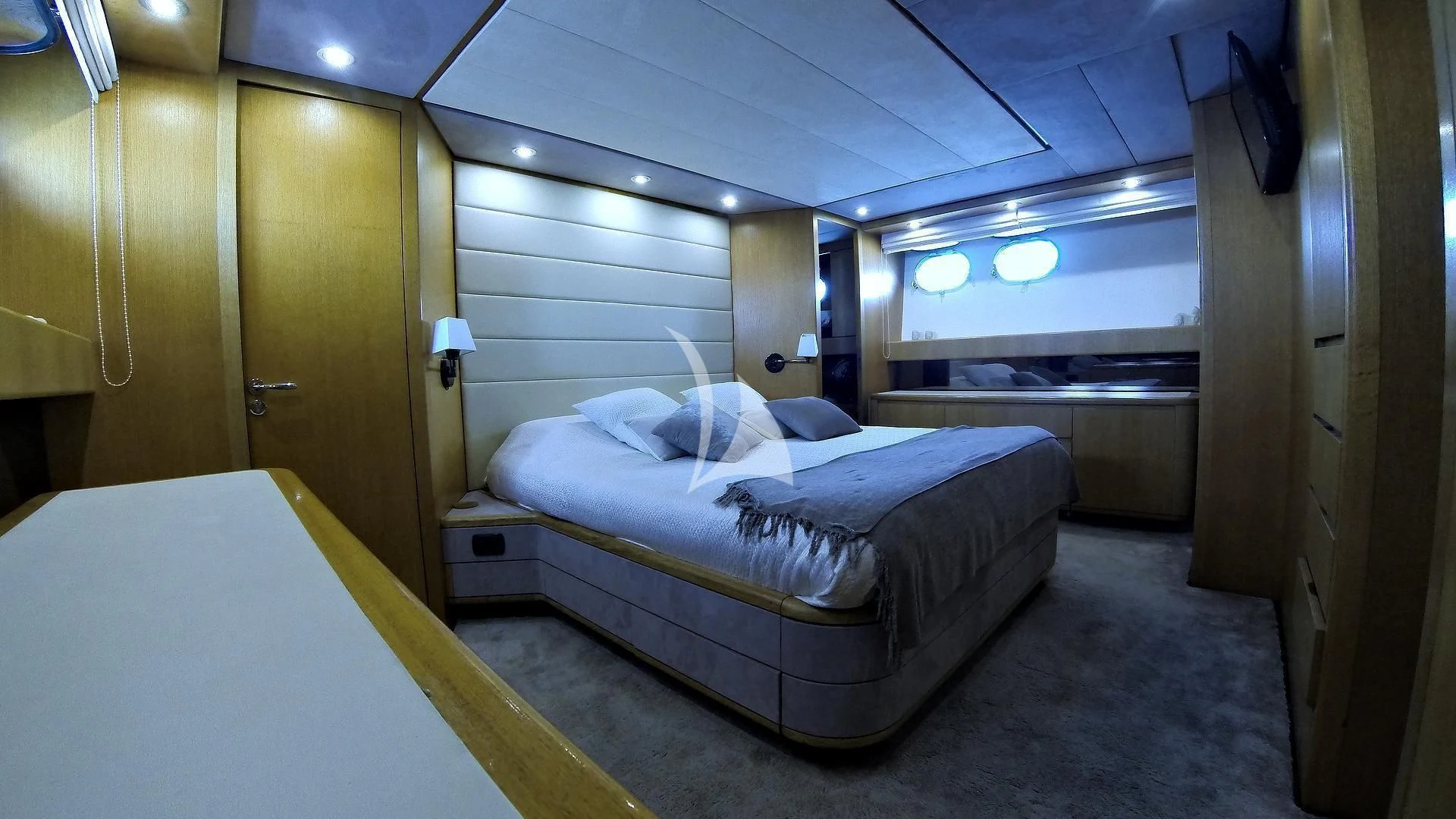 a room with beds and a door aboard LOLEA Yacht for Charter