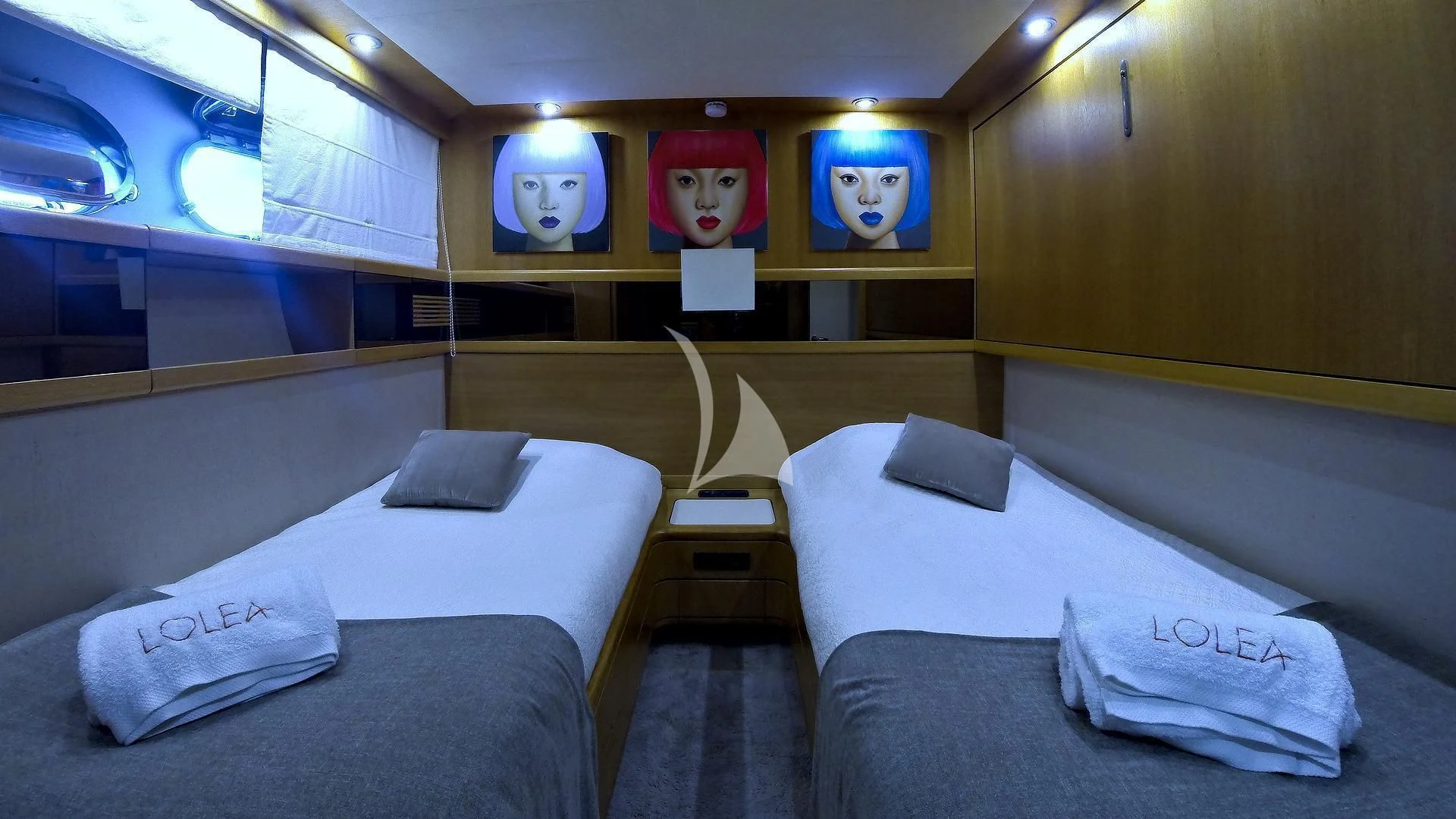 a room with beds and a desk aboard LOLEA Yacht for Charter
