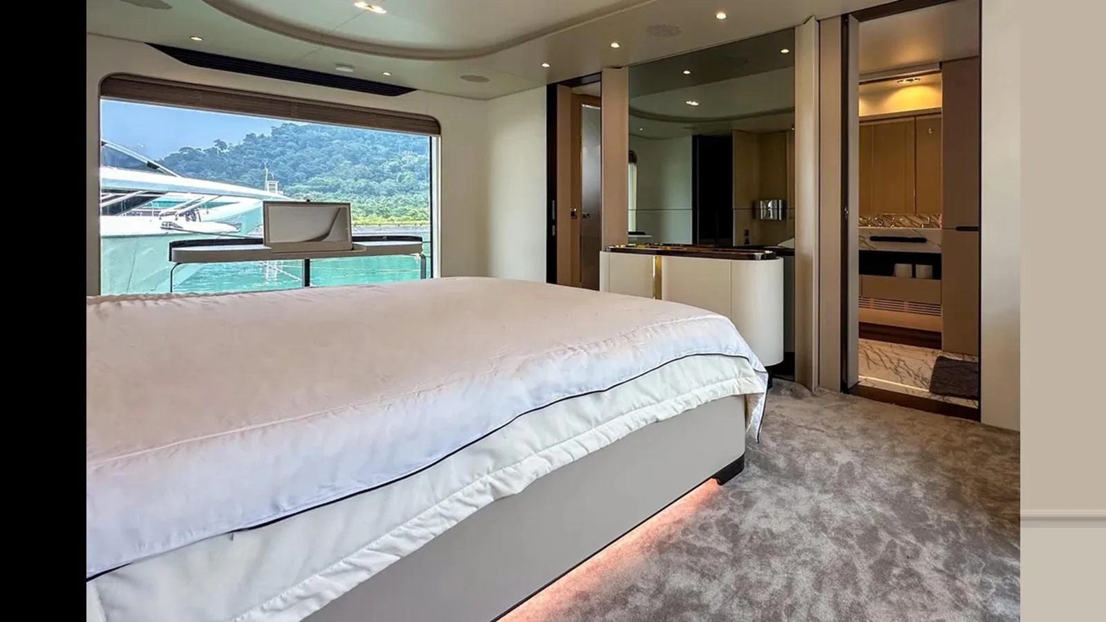 a room with a bed and a window aboard INFINITE VOYAGE III Yacht for Sale
