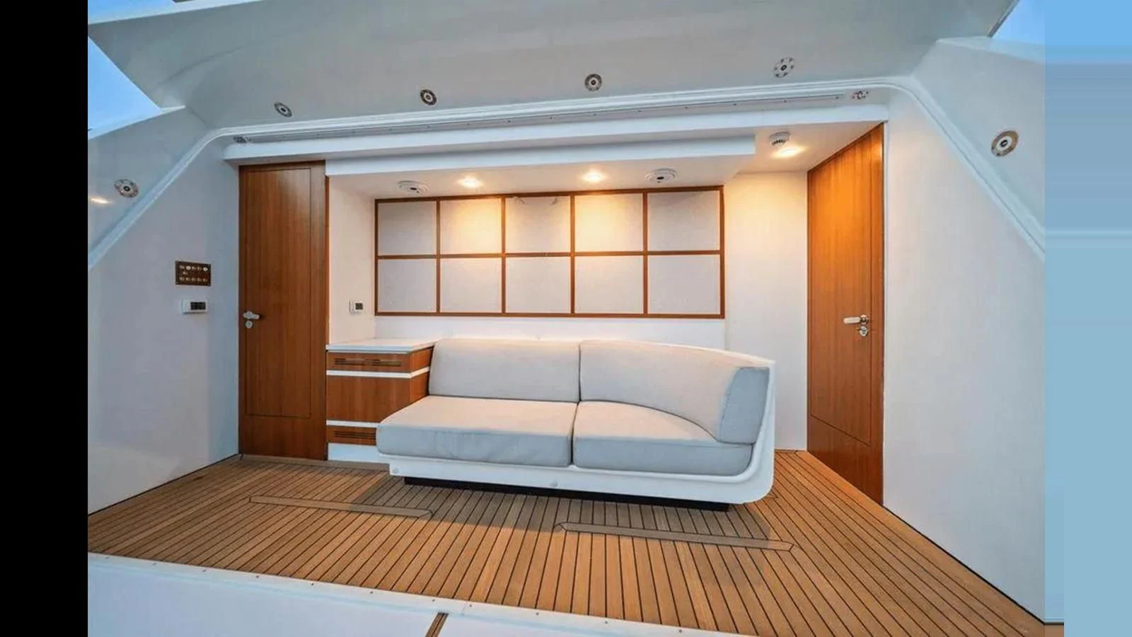 a room with a couch and a wood door aboard INFINITE VOYAGE III Yacht for Sale