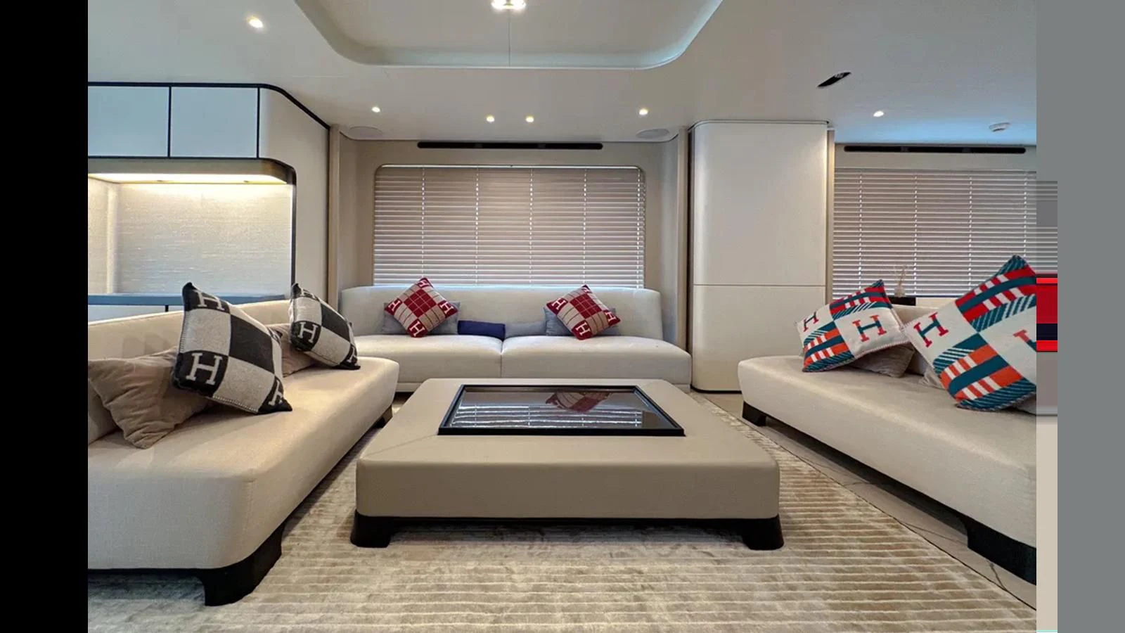 a living room with white couches and a coffee table aboard INFINITE VOYAGE III Yacht for Sale