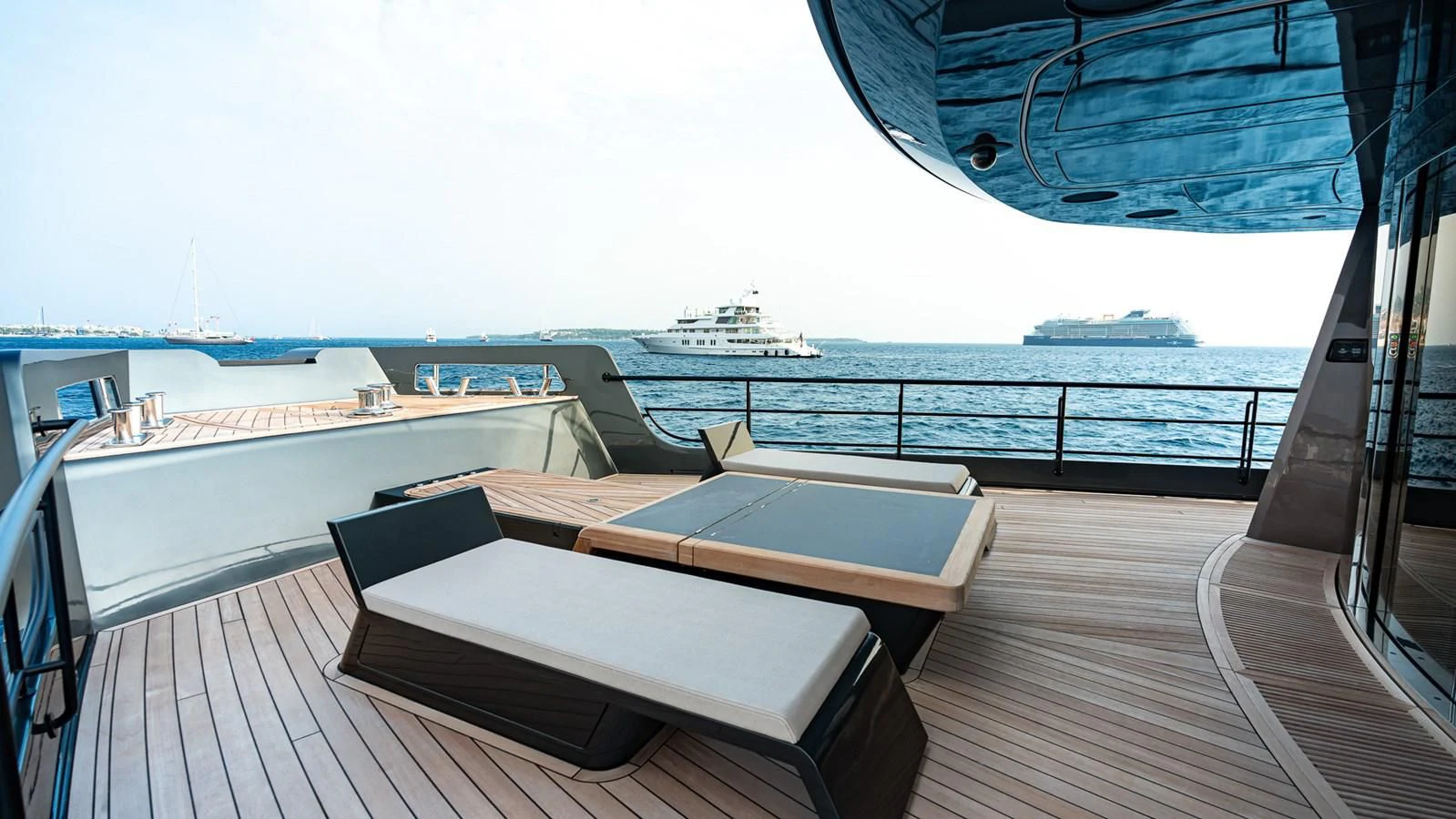 a deck with a view of the ocean and a large ship in the distance aboard EYE OF DESTINY Yacht for Sale