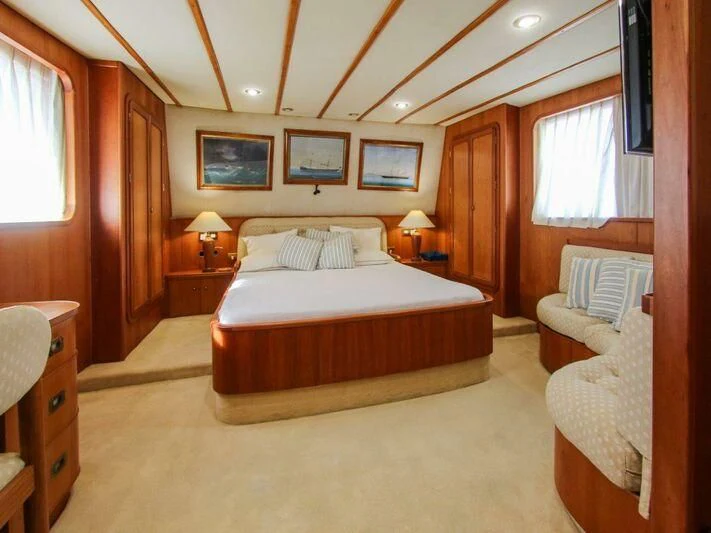 a bedroom with a bed and a chair aboard LA GRANDE DAME Yacht for Sale