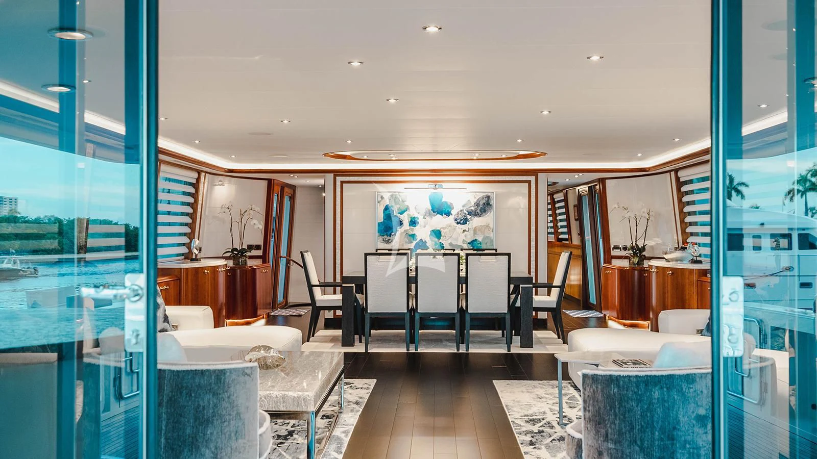 a room with a table chairs and a view of the city aboard LA LADY Yacht for Sale