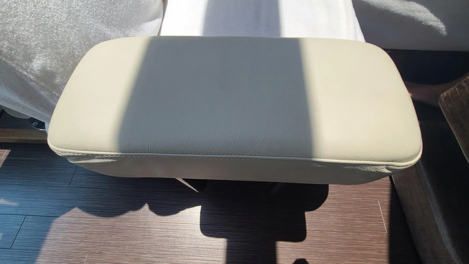 a white chair on a wood floor aboard PREDATOR 68 Yacht for Sale