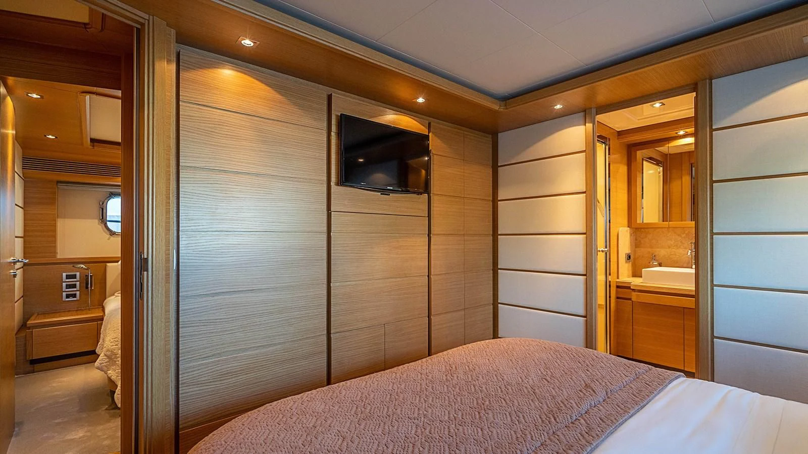 a room with a bed and a television aboard PATRON Yacht for Sale