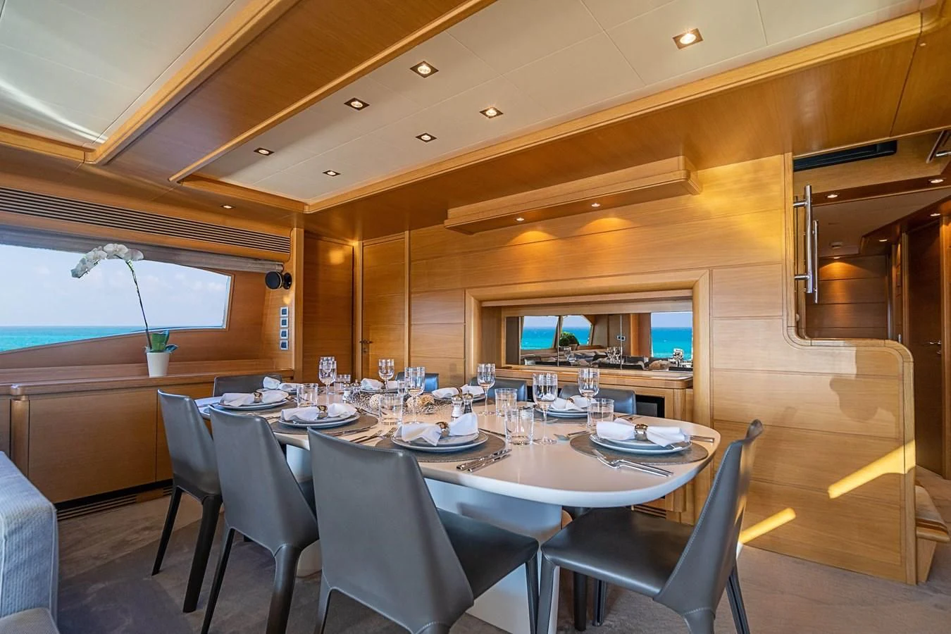 a dining room with a table set for dinner aboard PATRON Yacht for Sale