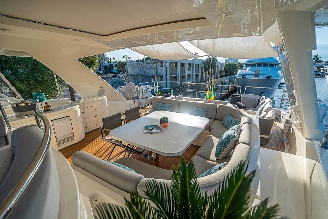 a room with a table chairs and plants on the floor aboard PATRON Yacht for Sale