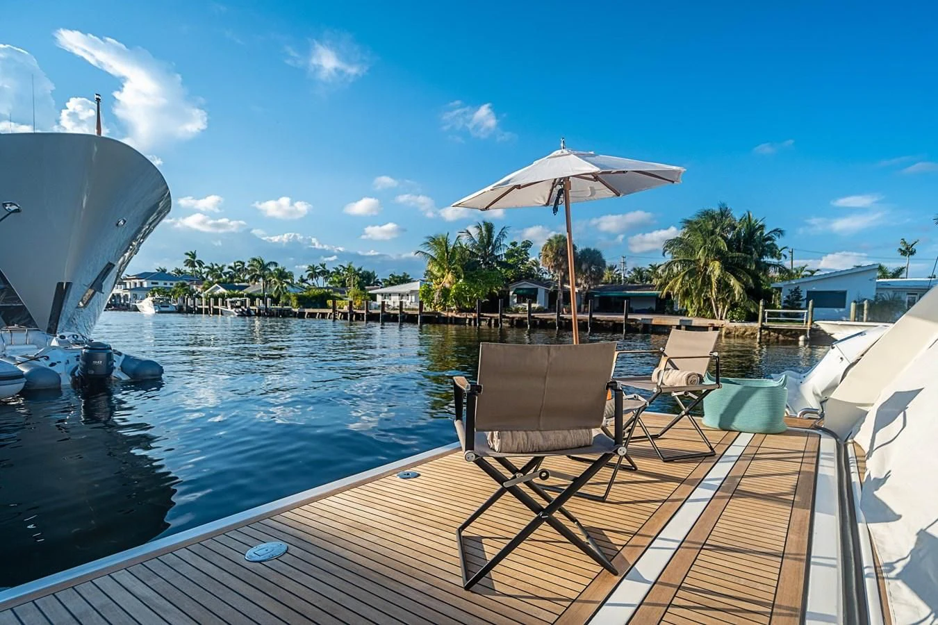 a deck with chairs and umbrellas on it by a body of water aboard PATRON Yacht for Sale