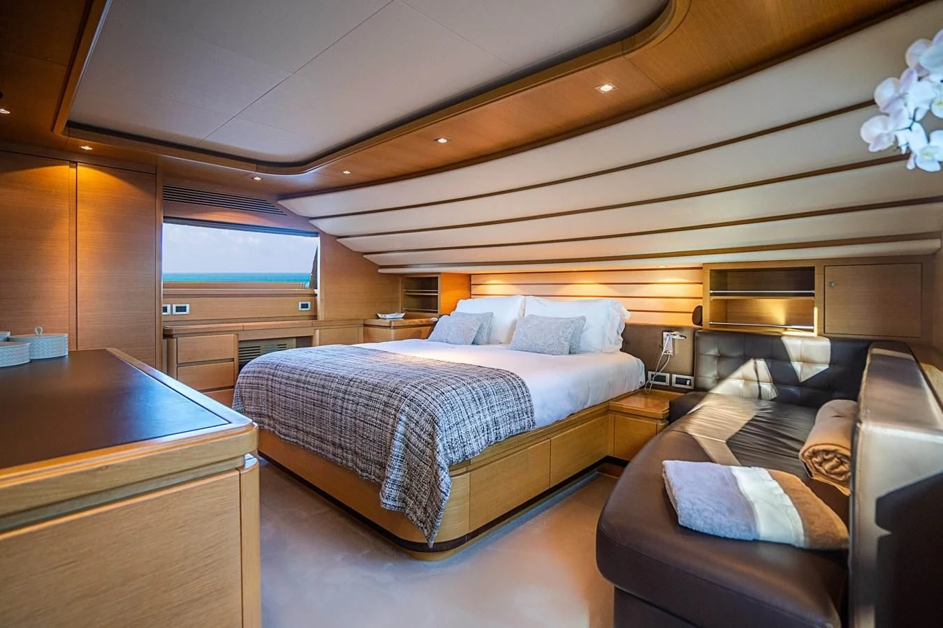 a bedroom with a bed and a couch aboard PATRON Yacht for Sale