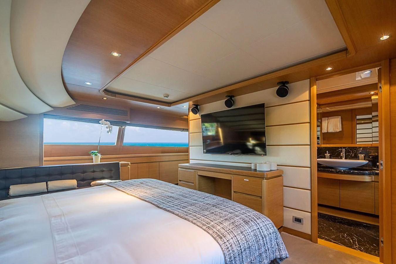 a bedroom with a bed and a television aboard PATRON Yacht for Sale