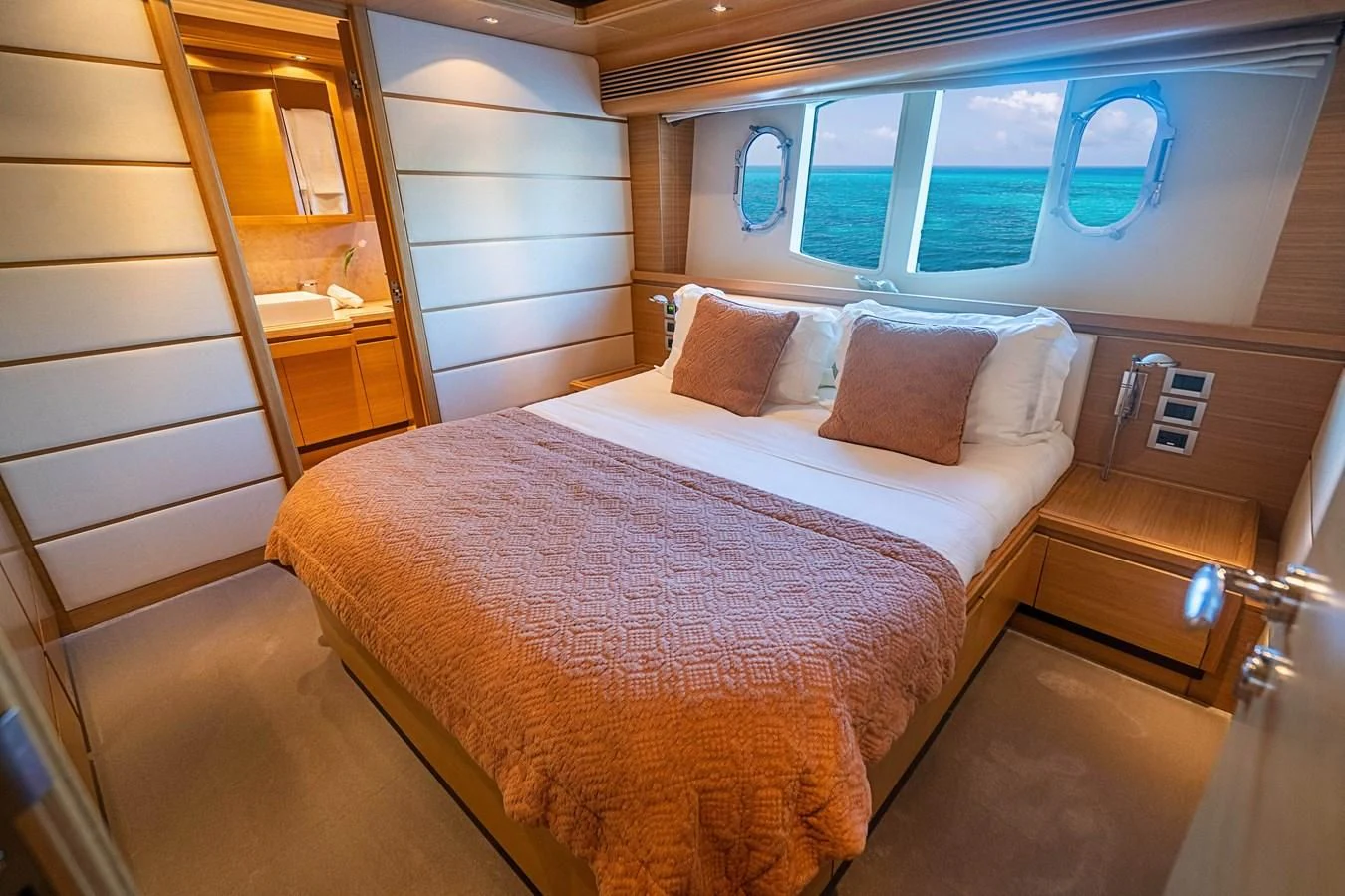 a bed with a pink comforter aboard PATRON Yacht for Sale